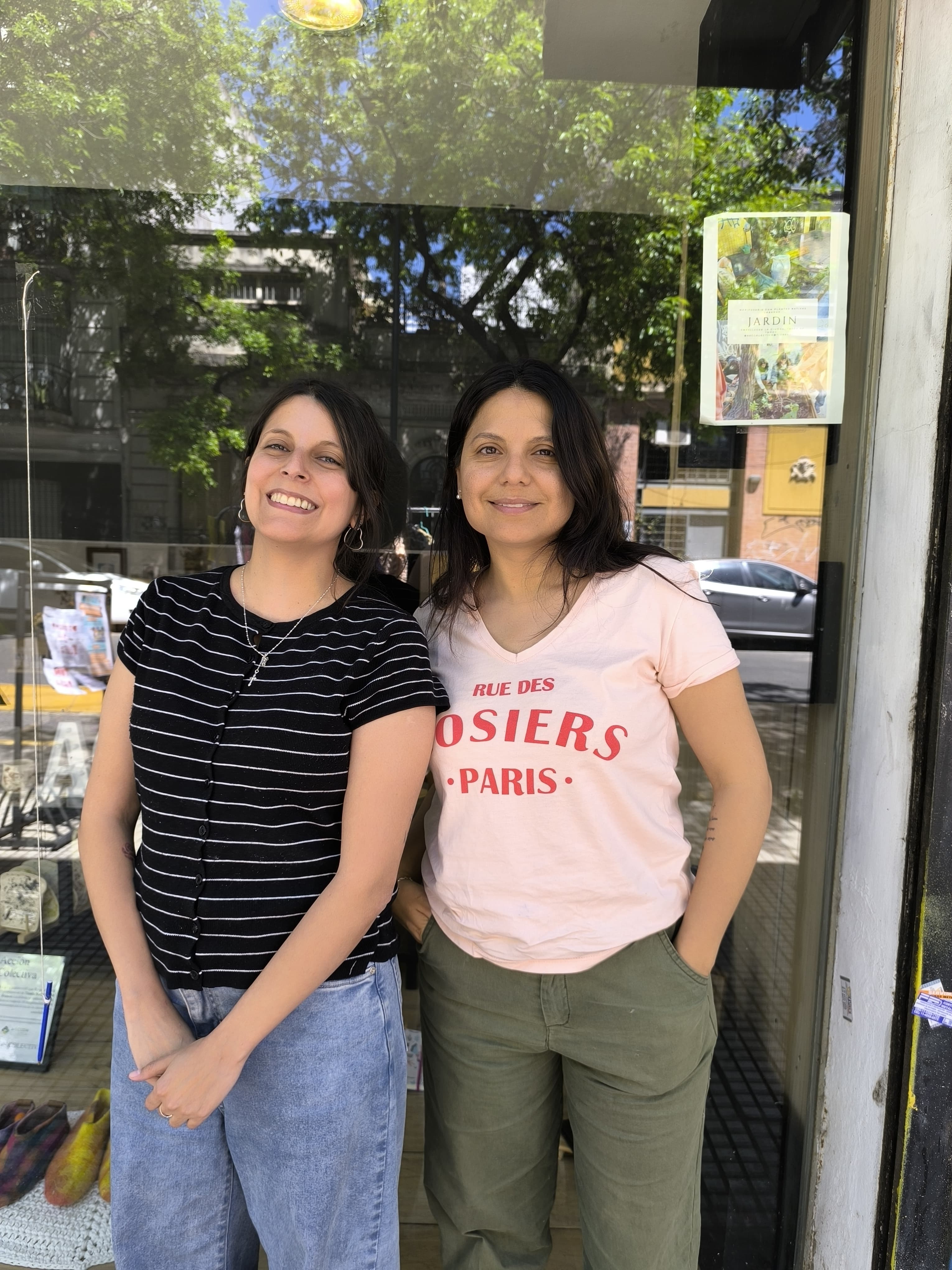 Dos mujeres sonriendo frente a una tienda